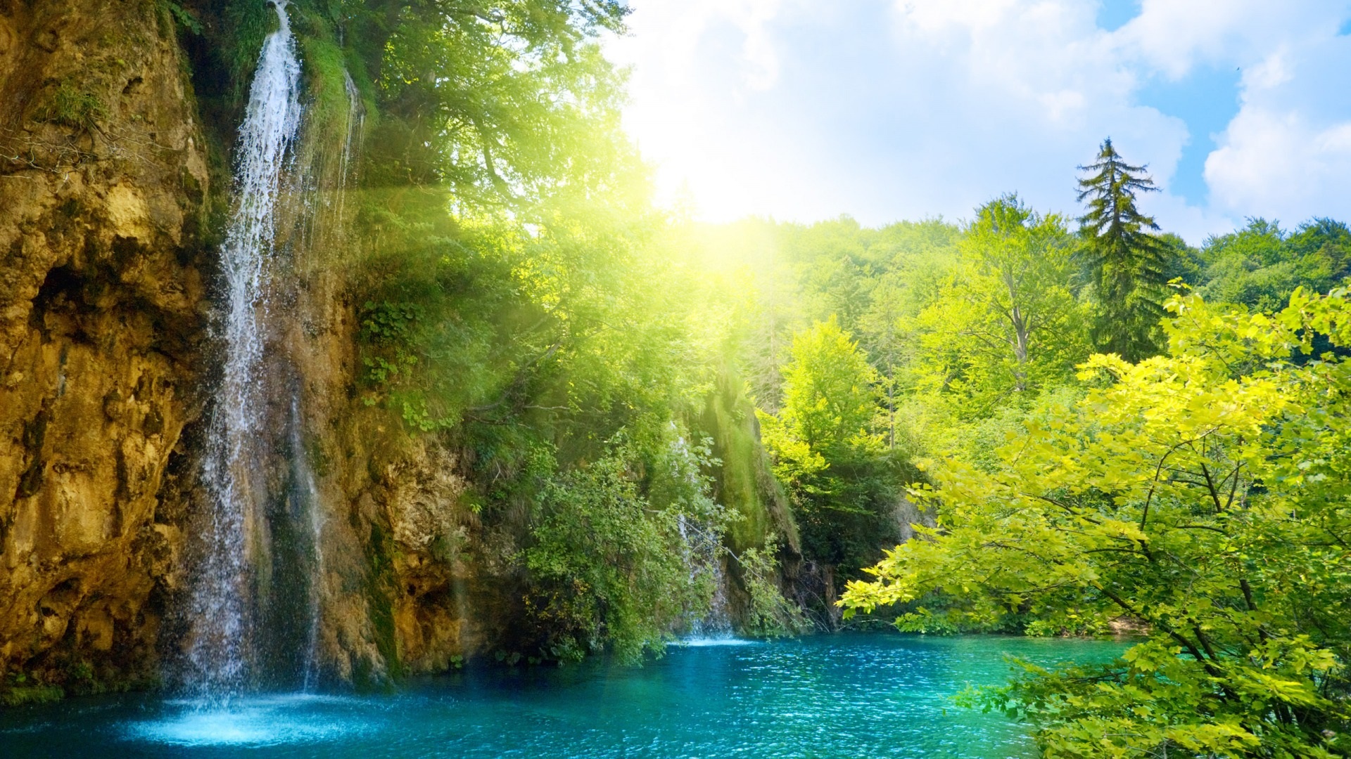 A sun-drenched lake with waterfalls